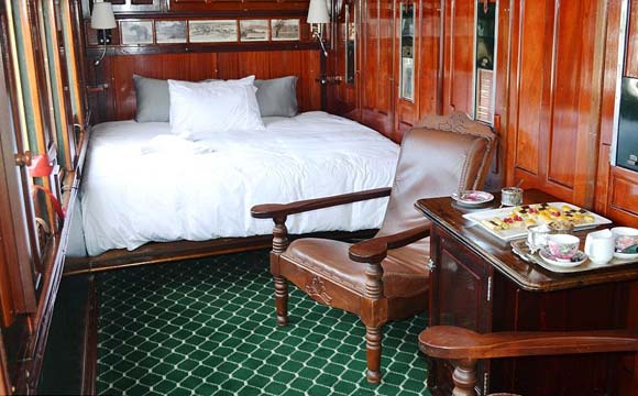 Quartos aconchegantes com cama de casal, painéis de madeira e mobiliário vintage