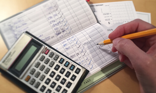 Imagem de uma pessoa fazendo contas com calculadora