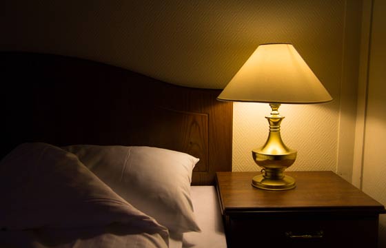 Luminária no criado-mudo é decorativa e evita que a pessoa precise circular pelo quarto no escuro