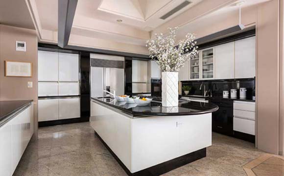 Cozinha ampla, com grande balcão em mármore
