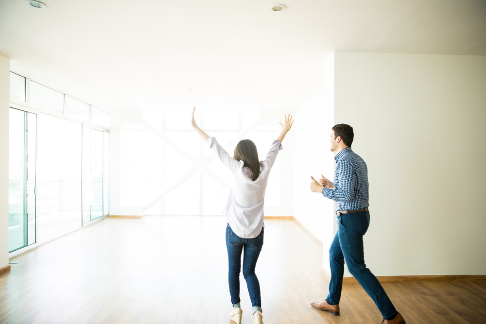 Casal animado ao entrar no novo imóvel, como comprar um apartamento