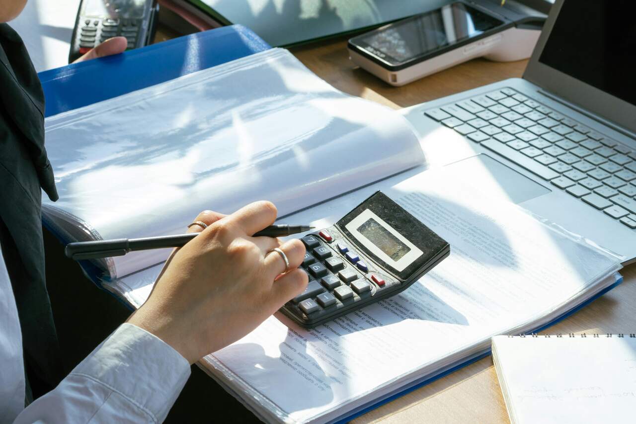 pessoa fazendo contas em uma calculadora