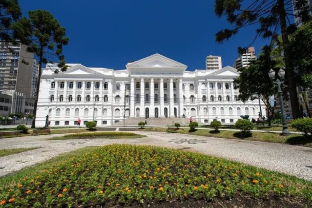 achada da Universidade Federal do Paraná, em Curitiba, construção em estilo clássico pintada de branco.