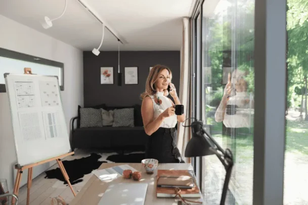 Edícula adaptada como home office com mesa de trabalho, iluminação natural e vista para o jardim.