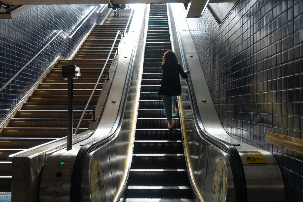 Mulher subindo as escadas de uma estação de metrô em São Paulo, estação Sacomã