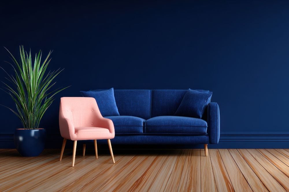 Sala de estar com sofá azul marinho e poltrona rosa claro, evidenciando uma variação