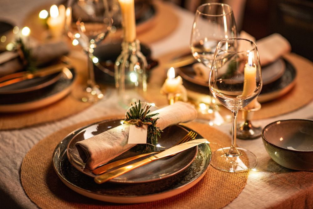 Configuração de mesa elegante para a ceia de Ano Novo com pratos escuros, talheres