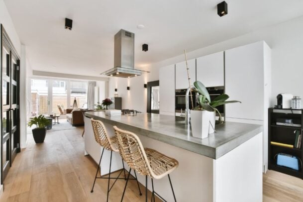 Cozinha gourmet moderna e integrada com sala de estar, representando o design e acabamento de alta qualidade de um lançamento de imóvel na planta.