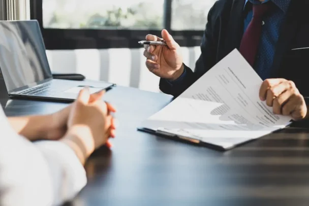 Pessoa analisando contrato de compra e venda com corretor para entender os direitos previstos em caso de cancelamento conforme a lei do distrato.