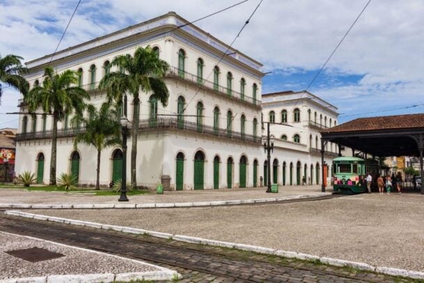 Museu do Café, edifício histórico de três andares com arquitetura clássica branca e portas verdes em Santos.