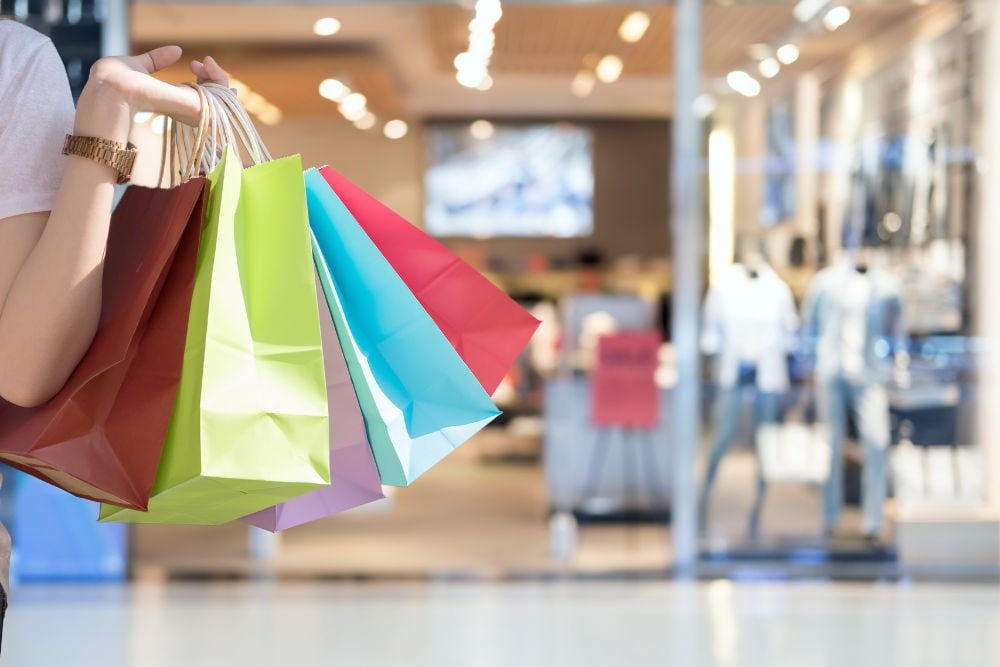 Detalhe de sacolas de compras coloridas em frente a lojas de grife no Shopping Leblon.