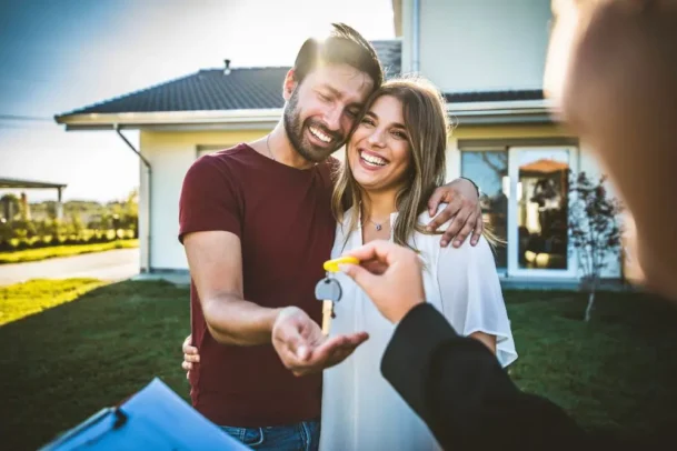 Casal feliz recebendo chave de casa do programa minha casa, minha vida.