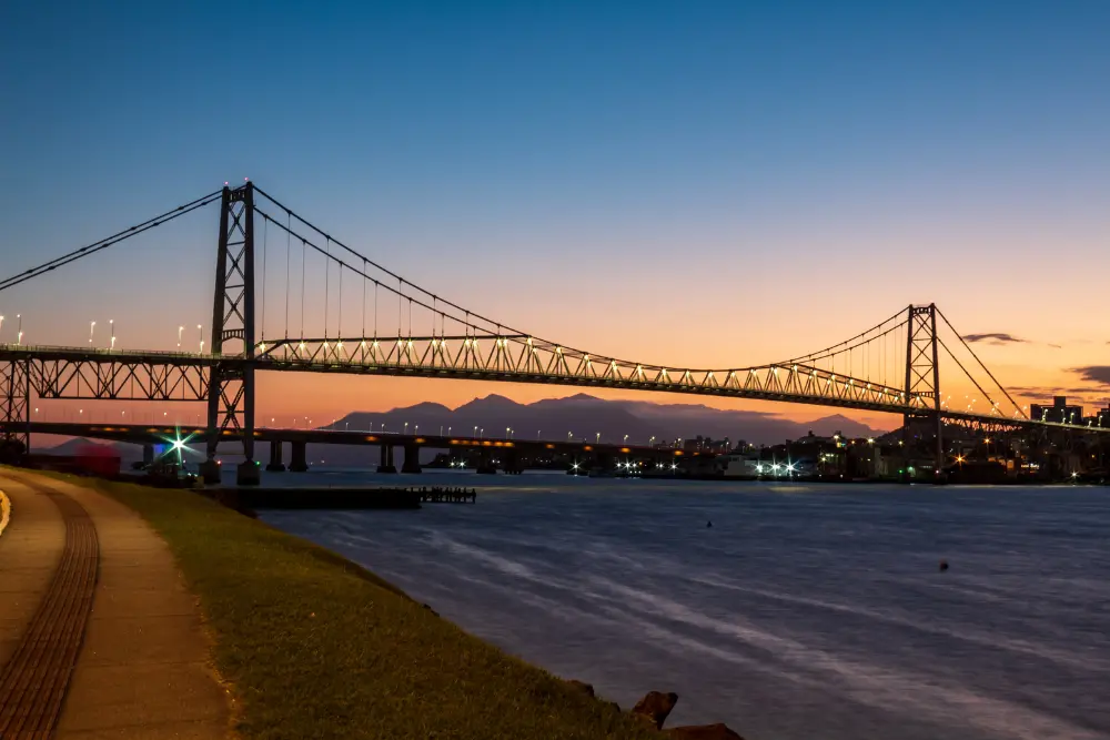 Vista da Ponte Hercílio Luz ao entardecer em Florianópolis, destacando paisagem urbana e qualidade de vida em cidades com maior IDH do Brasil reconhecidas nacionalmente.
