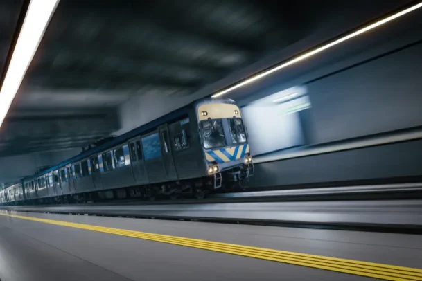 Trem em movimento dentro de túnel subterrâneo nas estações de metrô do RJ, representando velocidade, transporte urbano e deslocamento diário no Rio de Janeiro.