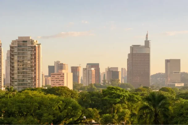 Vista urbana arborizada da Zona Oeste paulistana comparando estilos residenciais em pinheiros-ou-vila-madalena durante amanhecer ensolarado.
