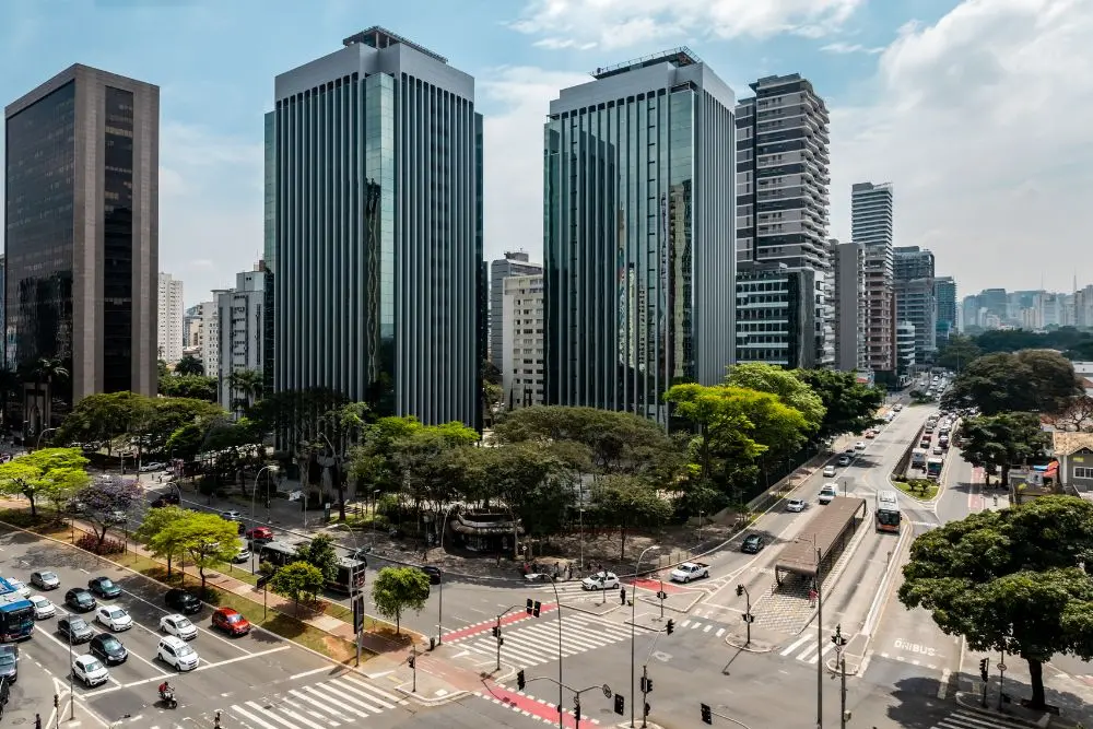 Encontro entre ruas em São Paulo, com grandes prédios e muita movimentação nas calçadas.